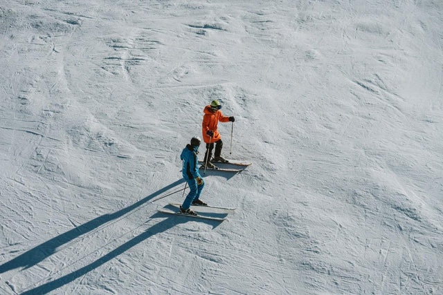 Moniteur de ski expliquant la technique à un élève sur une piste de Baqueira