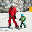 Enfant qui apprend à skier avec son moniteur
