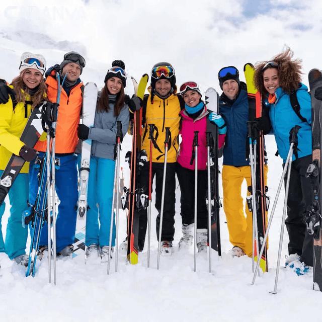 Groupe d’amis souriants dans la neige avec leurs skis et leurs bâtons